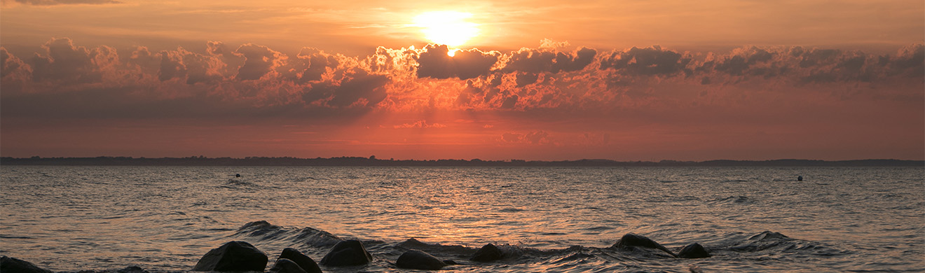 Ruhige Landschaft am Meer bei Sonnenuntergang – Symbol für Frieden, Abschied und anonyme Bestattung in Aachen.