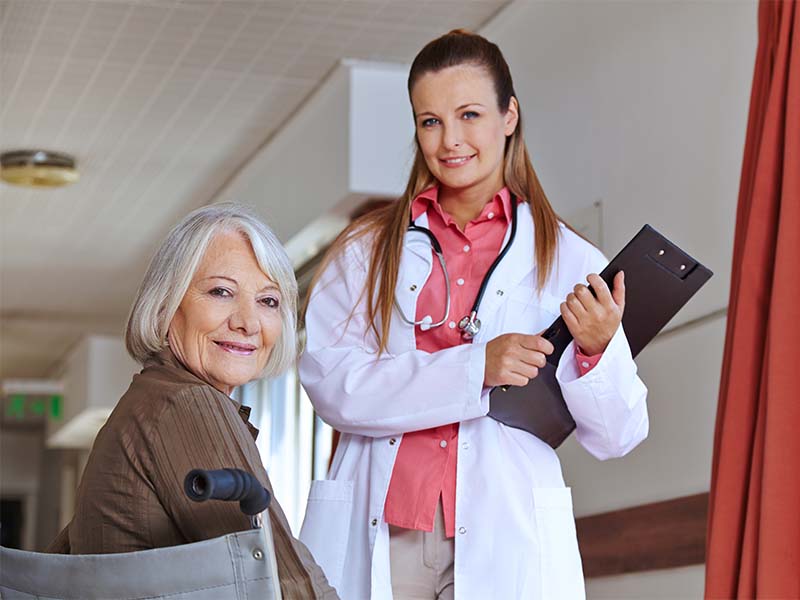 Seniorin in Klinik bespricht mit Krankenschwester die festgelegten Inhalte der Patientenverfügung